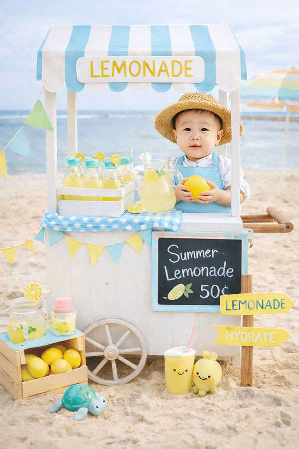 First birthday photoshoot of a baby at a lemonade stand on the beach