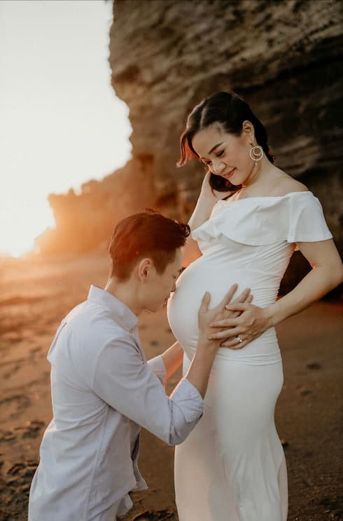 Maternity photoshoot of a couple at the beach during sunset